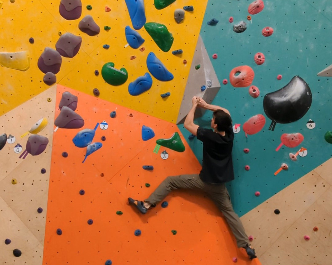 young man climbing on a bouldering wall